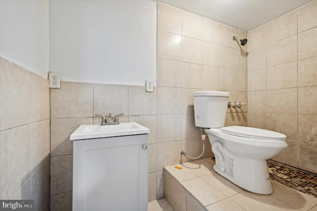 bathroom with vanity, toilet, and tile walls