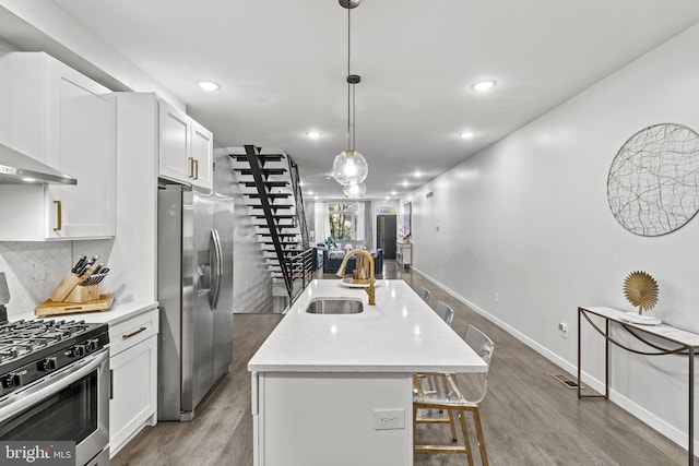 6127 Lebanon Ave, Philadelphia, PA 19151 - kitchen featuring appliances with stainless steel finishes, a sink, white cabinets, a center island with sink, and tasteful backsplash