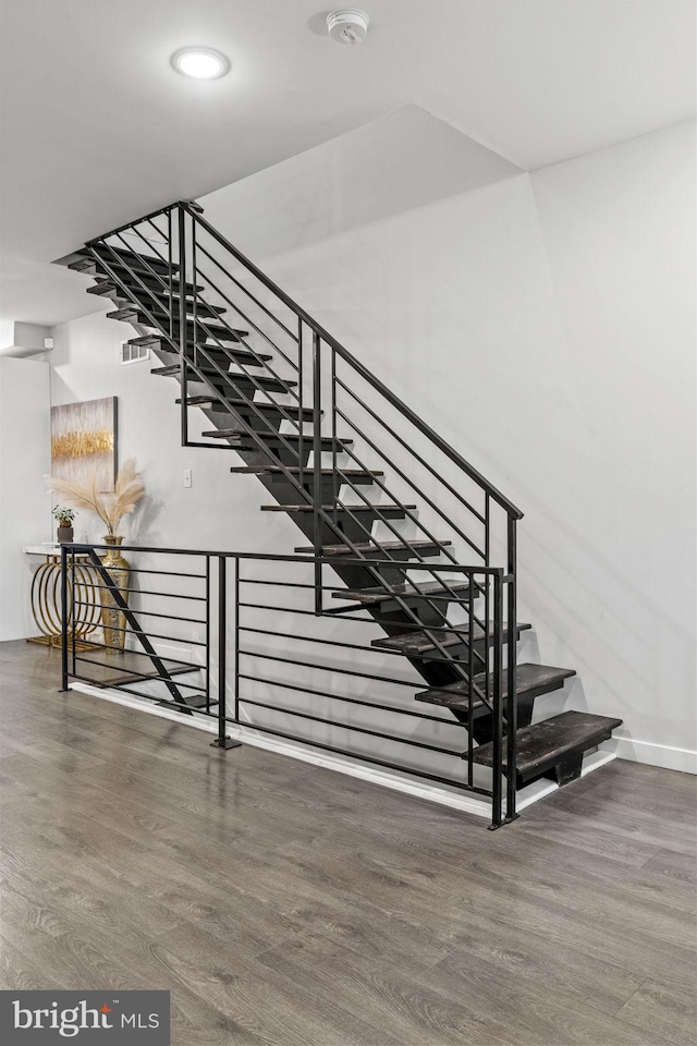 staircase with hardwood / wood-style floors