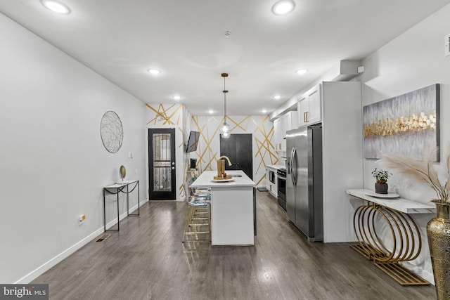 kitchen featuring white cabinetry, stainless steel refrigerator with ice dispenser, pendant lighting, a breakfast bar, and a center island with sink