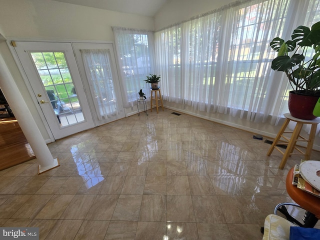 interior space featuring ornate columns, french doors, and lofted ceiling