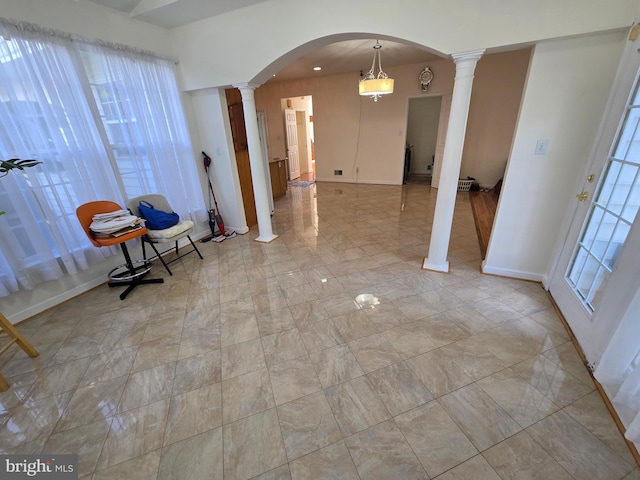 tiled entrance foyer with decorative columns and a wealth of natural light