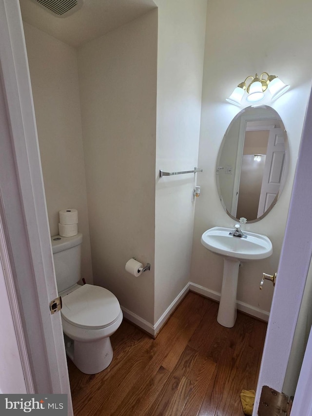 bathroom featuring hardwood / wood-style floors and toilet