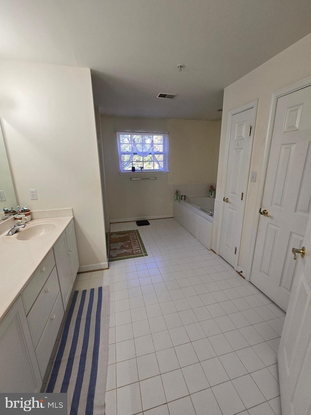 bathroom with tile patterned flooring, vanity, and a bathtub