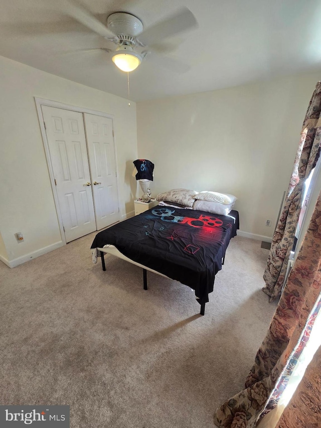 bedroom with ceiling fan, a closet, and light colored carpet