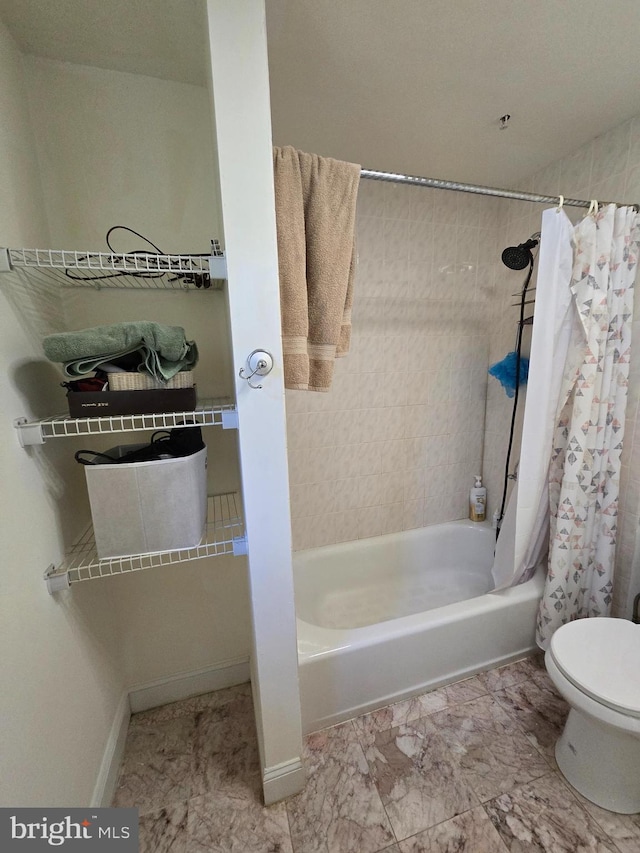 bathroom featuring shower / bath combination with curtain and toilet