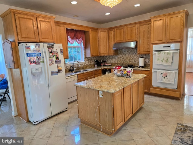 kitchen with light stone counters, white appliances, sink, light tile patterned floors, and a kitchen island