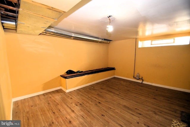 basement featuring baseboards and wood finished floors