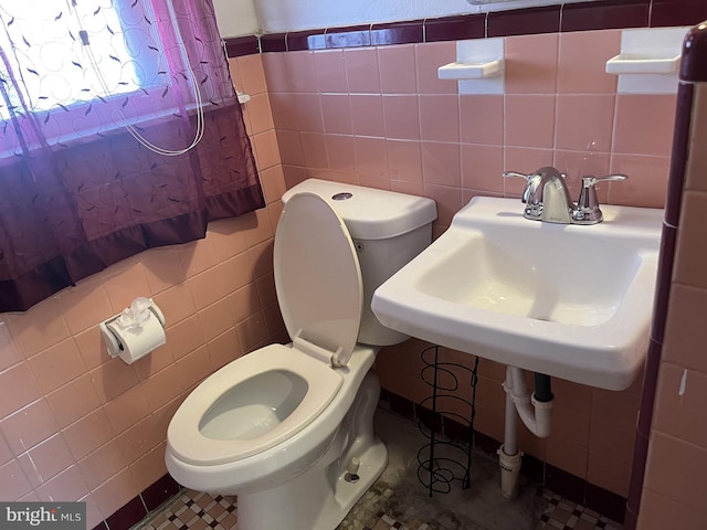 bathroom with toilet and tile walls