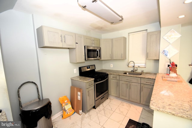 kitchen with light stone counters, marble finish floor, stainless steel appliances, a sink, and recessed lighting