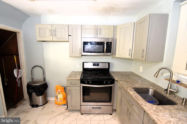 kitchen featuring stainless steel appliances, a sink, baseboards, marble finish floor, and light stone countertops