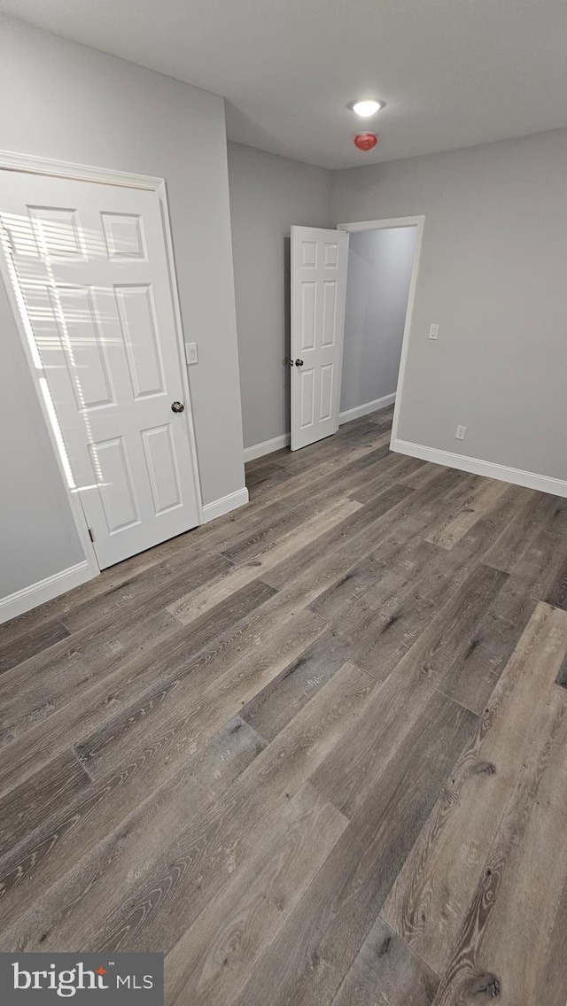 unfurnished room featuring dark wood-type flooring