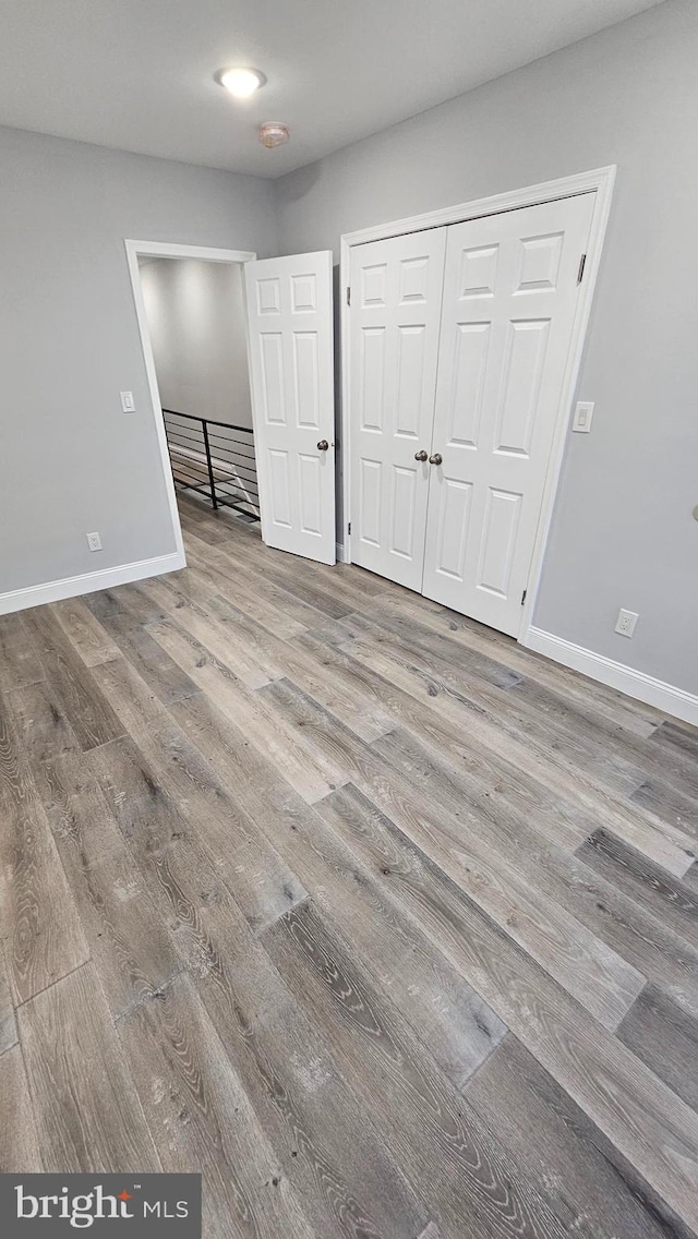 unfurnished bedroom with hardwood / wood-style flooring and a closet