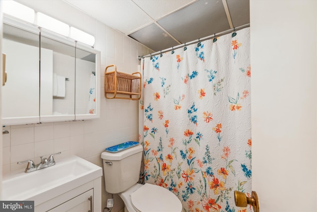 bathroom featuring tasteful backsplash, tile walls, vanity, a shower with shower curtain, and toilet