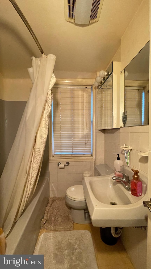 full bathroom with sink, toilet, tile walls, shower / bath combination with curtain, and backsplash