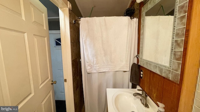 bathroom with a shower with shower curtain and sink