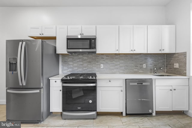 kitchen with backsplash, white cabinetry, sink, and appliances with stainless steel finishes