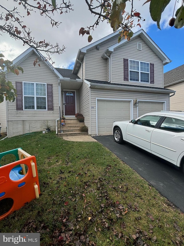 view of front of property featuring a front yard and a garage