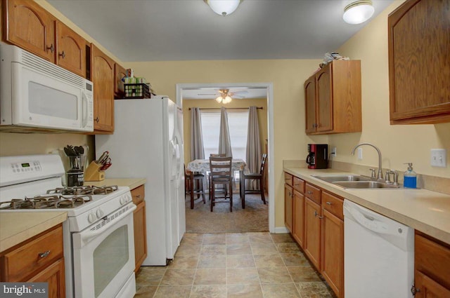 kitchen featuring ceiling fan, white appliances, sink, and light carpet