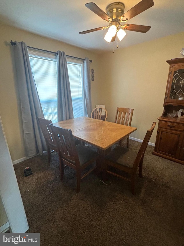 dining space featuring dark carpet and ceiling fan