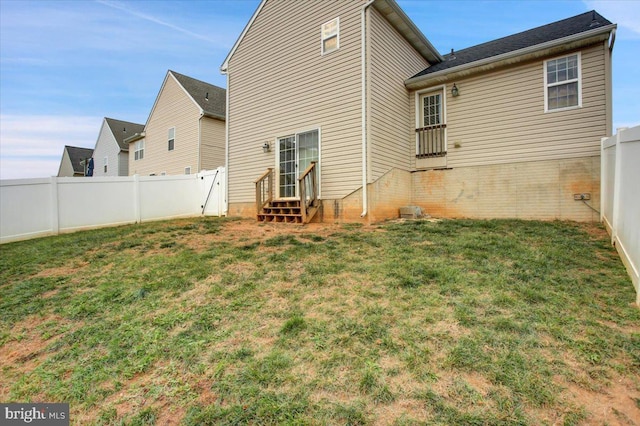 rear view of house featuring a yard