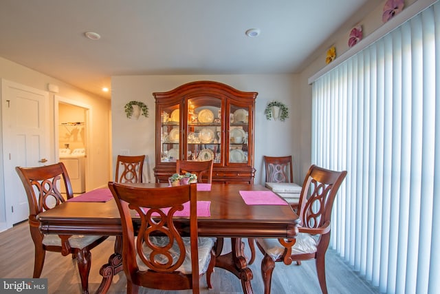 dining area featuring washer and clothes dryer and light hardwood / wood-style flooring