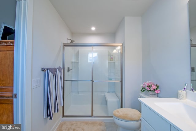 bathroom with vanity, tile patterned floors, toilet, and a shower with shower door