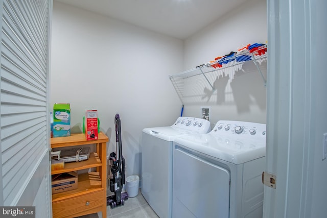 laundry room with light tile patterned floors and washer and clothes dryer