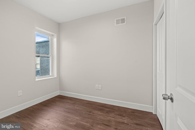 spare room with dark wood-type flooring