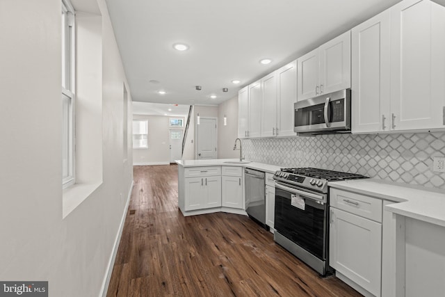 kitchen featuring stainless steel appliances, white cabinets, sink, and dark wood-type flooring