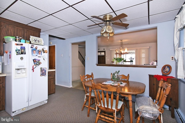 carpeted dining area featuring ceiling fan with notable chandelier and a baseboard radiator