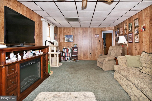 carpeted living room with wood walls