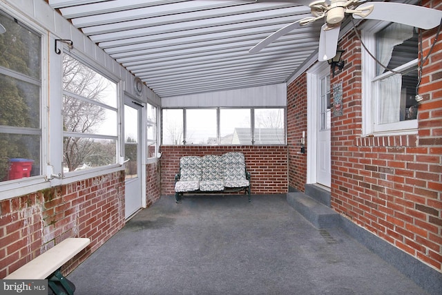 unfurnished sunroom featuring ceiling fan, a healthy amount of sunlight, and lofted ceiling