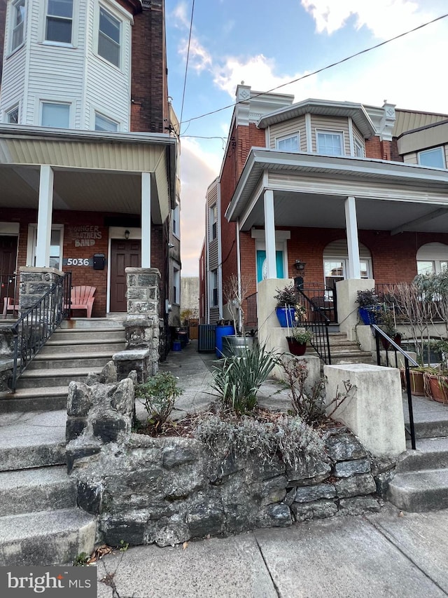 property exterior at dusk featuring a porch