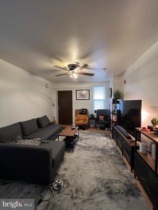 living room featuring a textured ceiling and ceiling fan