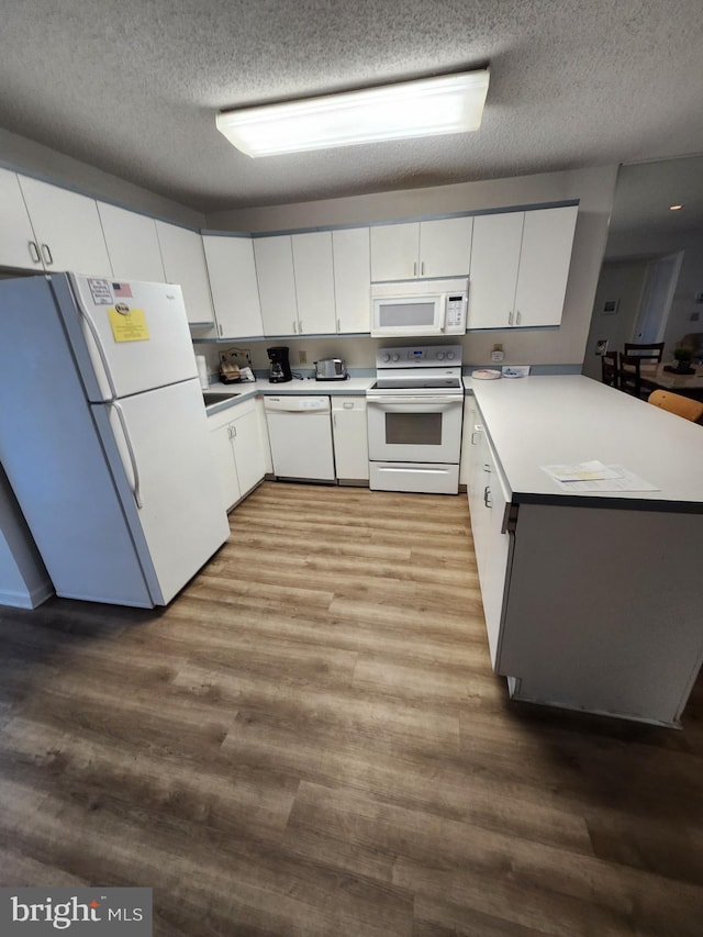 kitchen with white cabinetry, white appliances, light hardwood / wood-style flooring, and a textured ceiling