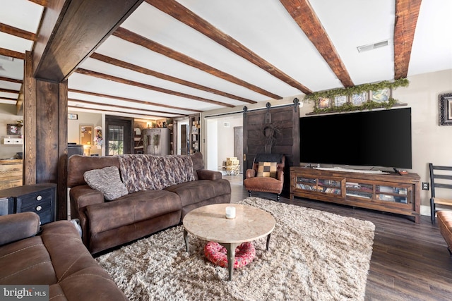 living room featuring beamed ceiling, a barn door, and dark hardwood / wood-style floors