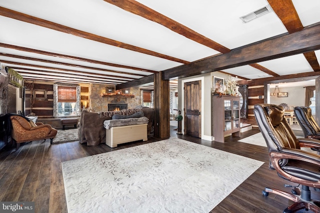 interior space with beamed ceiling, dark hardwood / wood-style floors, wood walls, and a fireplace