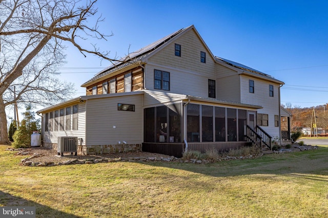 rear view of house featuring central AC, a sunroom, and a yard