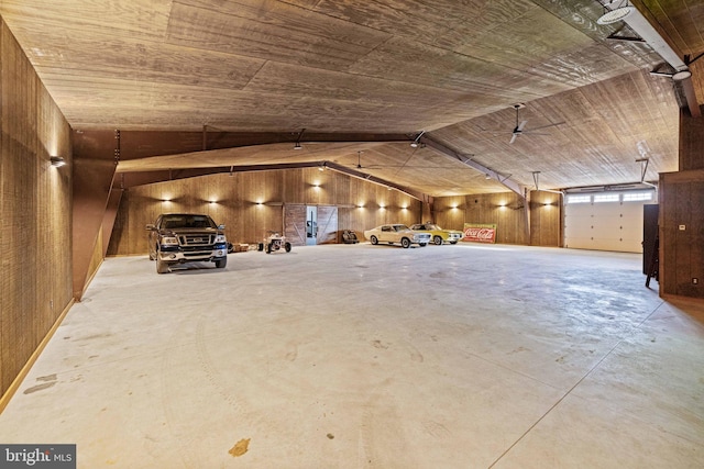 garage with wooden walls, a carport, and wood ceiling