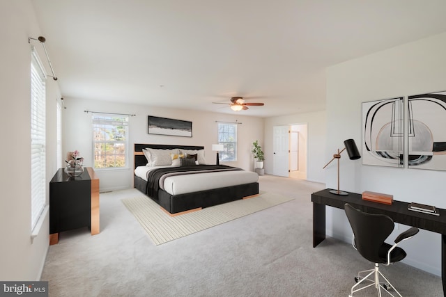 carpeted bedroom featuring multiple windows and ceiling fan