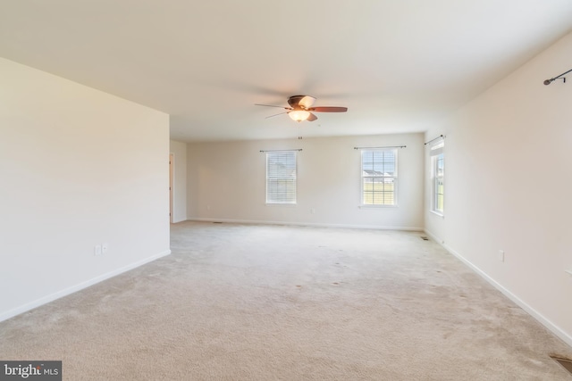 spare room featuring light carpet and ceiling fan