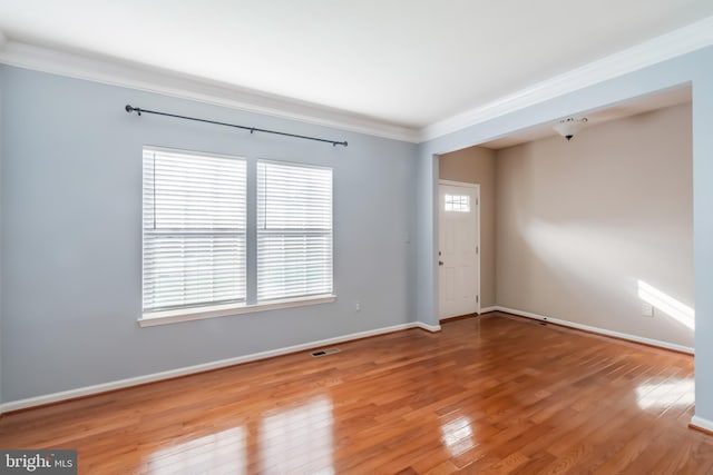 unfurnished room featuring wood-type flooring and crown molding