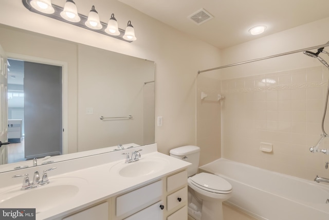 full bathroom with tiled shower / bath, toilet, and vanity