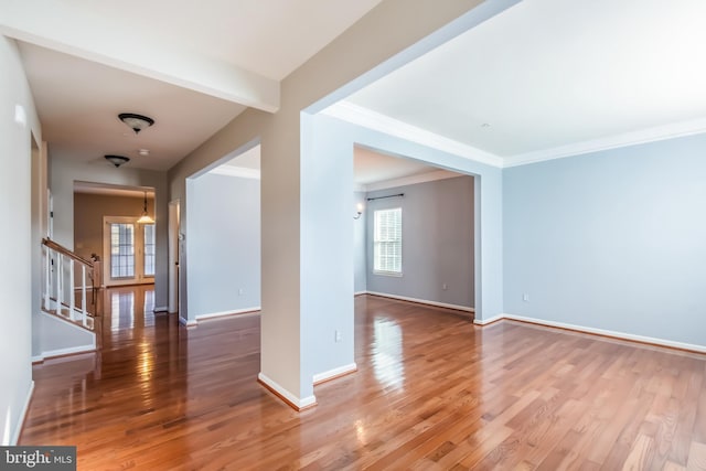 unfurnished room featuring wood-type flooring and ornamental molding