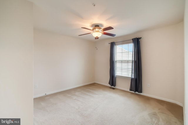 empty room featuring light colored carpet and ceiling fan