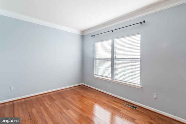 unfurnished room featuring hardwood / wood-style flooring and crown molding