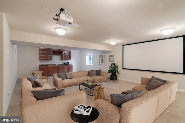 cinema room with light colored carpet and sink