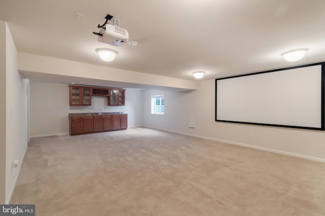 carpeted home theater room with sink