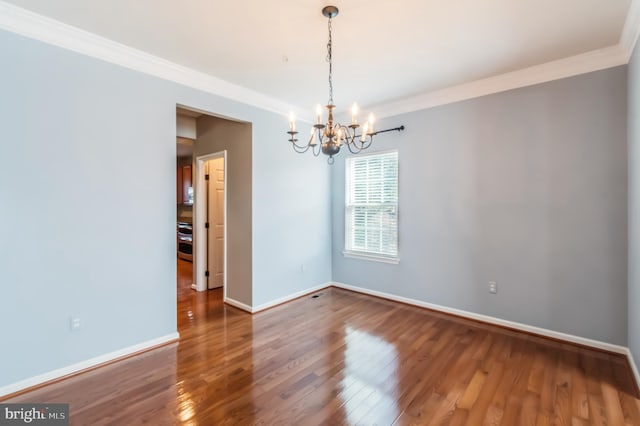 empty room with wood-type flooring, a notable chandelier, and crown molding